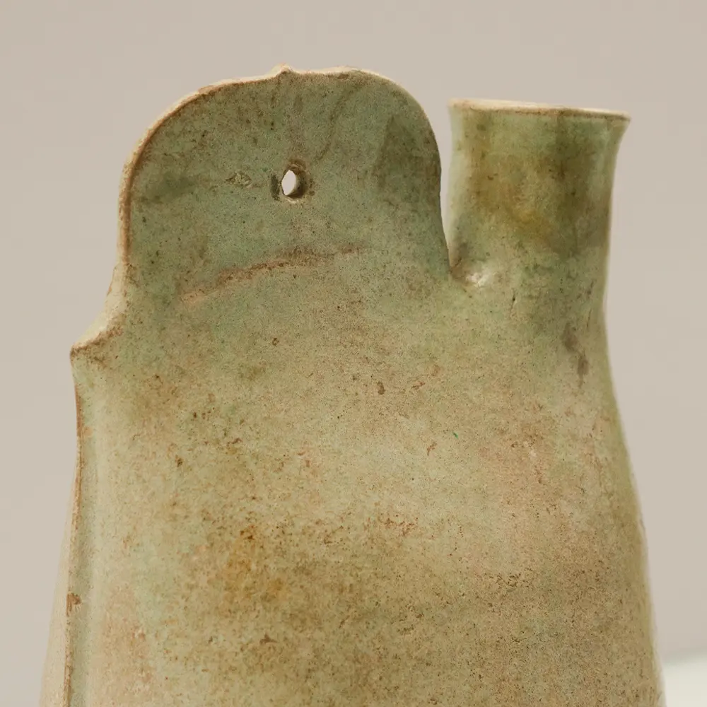 Close-up of the cockscomb suspension lug and cylindrical spout on a Liao Dynasty green glazed pottery flask