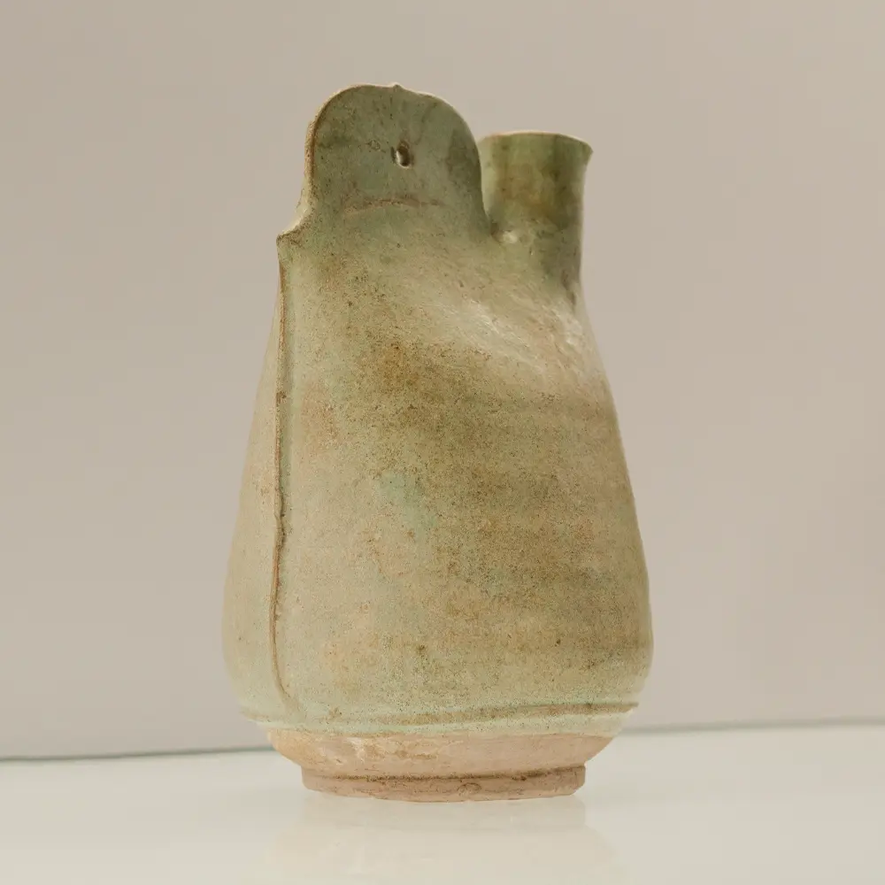 Full side profile of a green glazed Liao Dynasty cockscomb leather flask