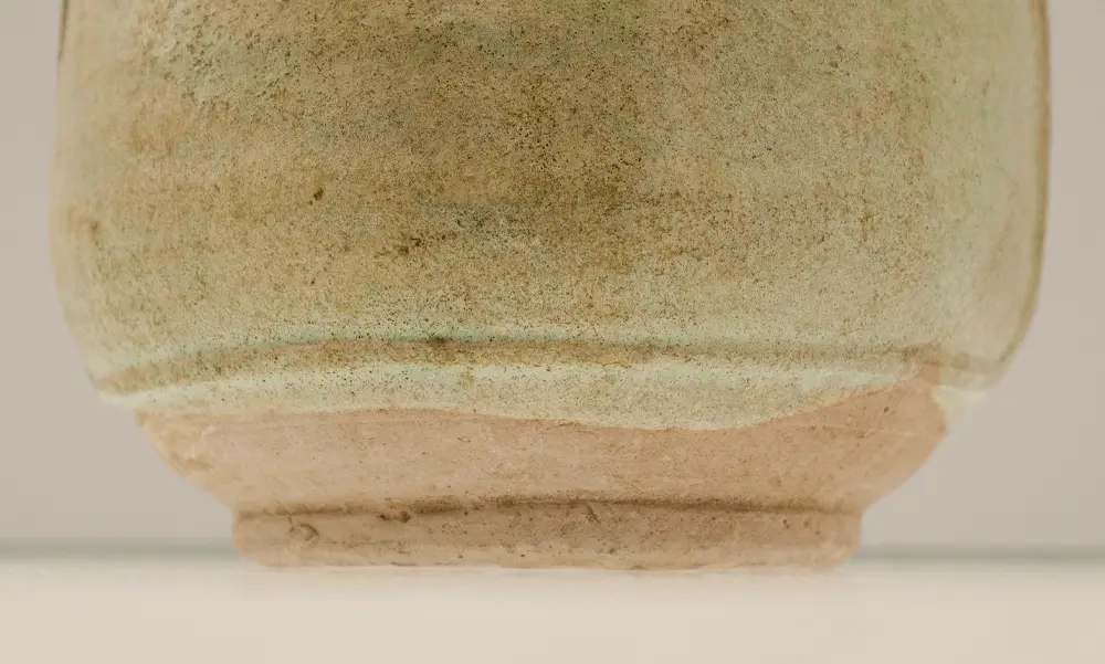 Close-up of the unglazed earthenware foot ring and glaze line on the base of a Liao Dynasty cockscomb flask